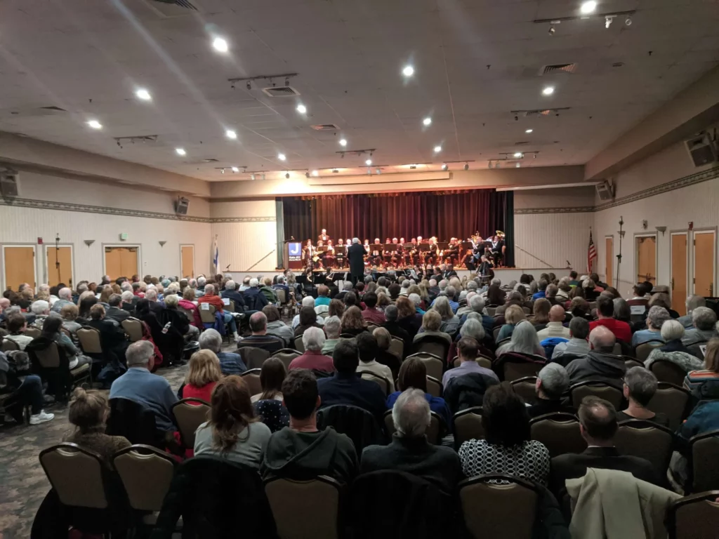 A group of people in a room with a band on a stage