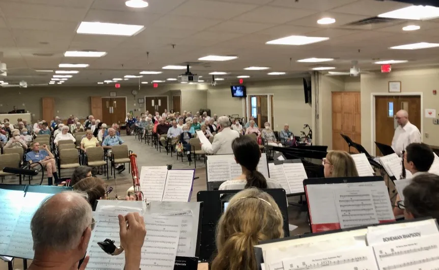 A group of people sitting in chairs with music sheets