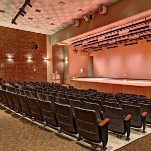 A large auditorium with a stage and chairs