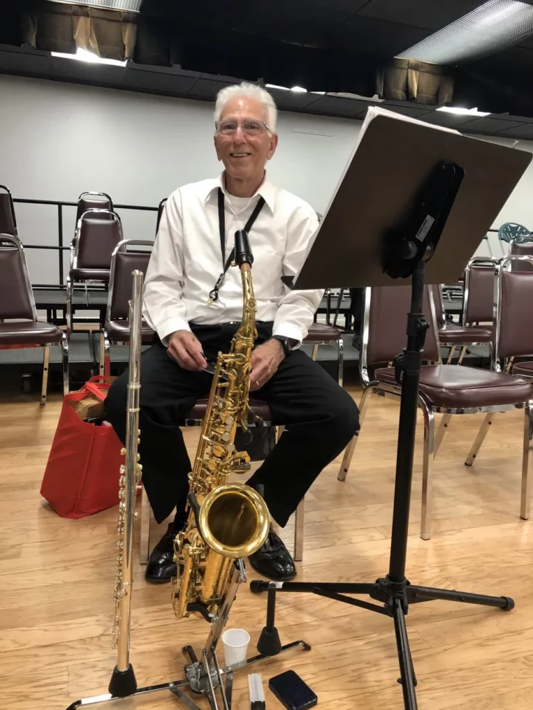 A person sitting on a chair with a saxophone